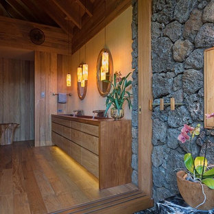 Esempio di una stanza da bagno padronale tropicale con ante lisce, ante in legno chiaro, pareti beige, pavimento in legno massello medio, lavabo rettangolare e top in legno