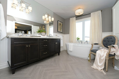 Large transitional master porcelain tile and beige floor freestanding bathtub photo in Other with shaker cabinets, dark wood cabinets, gray walls and an undermount sink