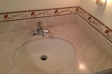 Example of a mid-sized master beige tile and porcelain tile alcove shower design in New York with a two-piece toilet, an integrated sink and solid surface countertops