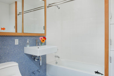 Example of a trendy blue tile and mosaic tile mosaic tile floor bathroom design in New York with a wall-mount sink, a one-piece toilet and white walls