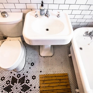 Esempio di una piccola stanza da bagno moderna con lavabo a colonna, vasca con piedi a zampa di leone, vasca/doccia, WC a due pezzi, piastrelle bianche, piastrelle in gres porcellanato, pareti beige e parquet chiaro