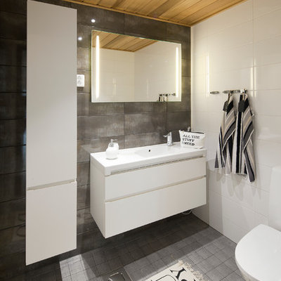 Danish bathroom photo in Devon with flat-panel cabinets, white cabinets and a two-piece toilet