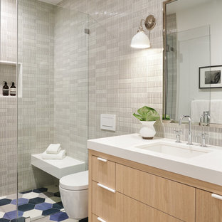 Large transitional kids' ceramic tile and gray tile cement tile floor and blue floor walk-in shower photo in San Francisco with flat-panel cabinets, light wood cabinets, a wall-mount toilet, an undermount sink, quartzite countertops, a hinged shower door and white countertops