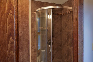 Идея дизайна: ванная комната среднего размера в стиле кантри с угловым душем, бежевой плиткой, черной плиткой, коричневой плиткой, каменной плиткой, полом из керамогранита и душевой кабиной