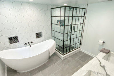 Mid-sized minimalist master gray tile and porcelain tile ceramic tile, gray floor and double-sink bathroom photo in New York with flat-panel cabinets, light wood cabinets, a one-piece toilet, gray walls, an undermount sink, quartzite countertops, a hinged shower door, white countertops and a freestanding vanity