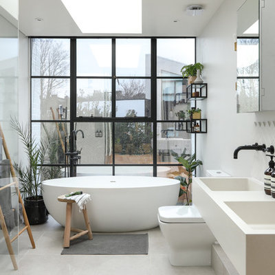 Example of a large danish 3/4 gray tile and ceramic tile ceramic tile and white floor bathroom design in London with white cabinets, a one-piece toilet, white walls, a wall-mount sink, marble countertops and white countertops