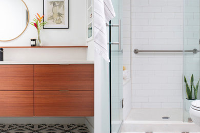 Inspiration for a small eclectic master white tile and ceramic tile cement tile floor, black floor and single-sink bathroom remodel with flat-panel cabinets, medium tone wood cabinets, a two-piece toilet, white walls, an undermount sink, quartz countertops, a hinged shower door, white countertops and a floating vanity