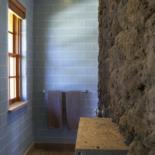 Esempio di una stanza da bagno tropicale con piastrelle di vetro, piastrelle blu, pavimento con piastrelle di ciottoli e pavimento beige