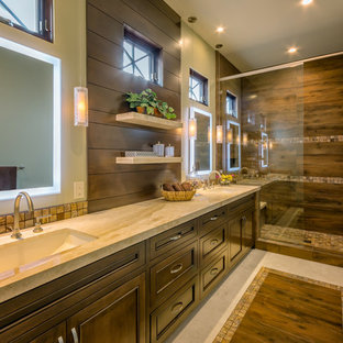 Foto di una grande stanza da bagno padronale tropicale con ante con riquadro incassato, ante in legno bruno, doccia aperta, piastrelle beige, piastrelle di vetro, pareti beige, pavimento in travertino, lavabo a bacinella e top in granito