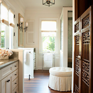 Foto di una stanza da bagno padronale tropicale di medie dimensioni con pavimento marrone, ante in stile shaker, ante bianche, doccia ad angolo, pareti bianche, parquet scuro, lavabo sottopiano e top in granito