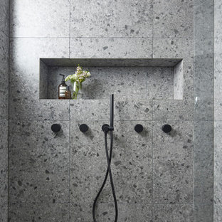 Inspiration för mellanstora moderna vitt en-suite badrum, med vita skåp, en dubbeldusch, en vägghängd toalettstol, grå kakel, stenhäll, grå väggar, terrazzogolv, ett väggmonterat handfat, laminatbänkskiva, grått golv, dusch med gångjärnsdörr och möbel-liknande