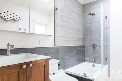Inspiration for a mid-sized transitional 3/4 gray tile and porcelain tile porcelain tile and beige floor bathroom remodel in San Francisco with recessed-panel cabinets, medium tone wood cabinets, quartz countertops, white countertops, a one-piece toilet, white walls and an integrated sink