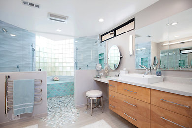Example of a large beach style master gray tile and ceramic tile porcelain tile and beige floor bathroom design in San Diego with flat-panel cabinets, light wood cabinets, a two-piece toilet, gray walls, a vessel sink, quartz countertops and white countertops