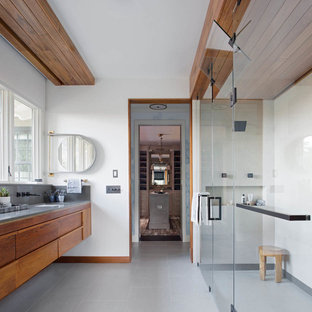 Ejemplo de cuarto de baño principal, contemporáneo, grande, con lavabo bajoencimera, armarios con paneles lisos, puertas de armario de madera oscura, ducha a ras de suelo, paredes blancas, suelo de baldosas de porcelana, encimera de cuarzo compacto, suelo gris y ducha con puerta con bisagras