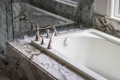 Mid-sized transitional master drop-in bathtub photo in Other with granite countertops and a hinged shower door
