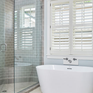 Idéer för små maritima beige en-suite badrum, med luckor med infälld panel, blå skåp, ett fristående badkar, en dusch i en alkov, grå kakel, keramikplattor, grå väggar, klinkergolv i keramik, ett undermonterad handfat, bänkskiva i kalksten, beiget golv och dusch med gångjärnsdörr
