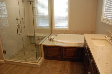 Example of a classic white tile and subway tile medium tone wood floor bathroom design in Other with raised-panel cabinets, dark wood cabinets, beige walls, an undermount sink and quartz countertops