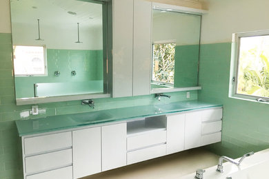 Inspiration for a large contemporary master bathroom remodel in Miami with glass-front cabinets, white cabinets, white walls and glass countertops