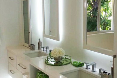 Foto de cuarto de baño principal actual de tamaño medio con armarios con paneles lisos, puertas de armario blancas, encimera de cuarzo compacto y lavabo bajoencimera