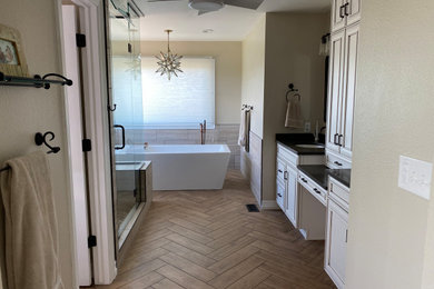 Bathroom - large master gray tile and porcelain tile porcelain tile, brown floor and double-sink bathroom idea in Denver with white cabinets, a one-piece toilet, gray walls, an undermount sink, a hinged shower door, black countertops, a niche and a built-in vanity
