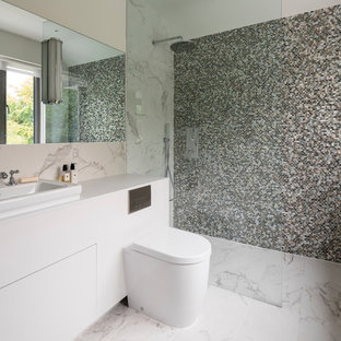 Photo of a large contemporary bathroom in London with flat-panel cabinets, beige cabinets, a corner shower, a one-piece toilet, mosaic tiles, marble flooring, a vessel sink, white floors, an open shower and white worktops.