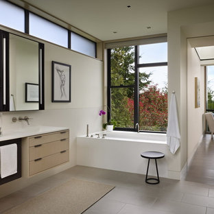 Inspiration for a modern bathroom remodel in Seattle with flat-panel cabinets, light wood cabinets and an undermount tub
