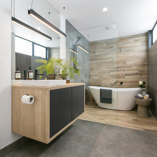 Photo of a contemporary master bathroom in Hobart with flat-panel cabinets, green cabinets, a freestanding tub, a curbless shower, a wall-mount toilet, gray tile, white walls, a vessel sink, wood benchtops, grey floor and an open shower.