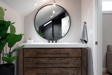 Small eclectic black tile and porcelain tile porcelain tile and multicolored floor bathroom photo in Boise with furniture-like cabinets, brown cabinets, gray walls, a trough sink, quartz countertops, a hinged shower door and white countertops