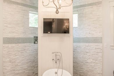 Lantlig inredning av ett badrum, med ett badkar med tassar, en öppen dusch och med dusch som är öppen