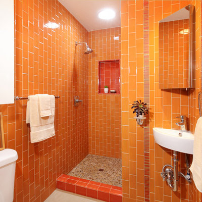 Eclectic orange tile pebble tile floor bathroom photo in Los Angeles with a wall-mount sink and orange walls