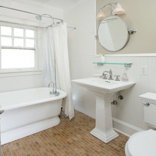 Photo of a victorian bathroom in Cleveland with a pedestal sink, a freestanding tub, a shower/bathtub combo, white tile, subway tile and brick floors.