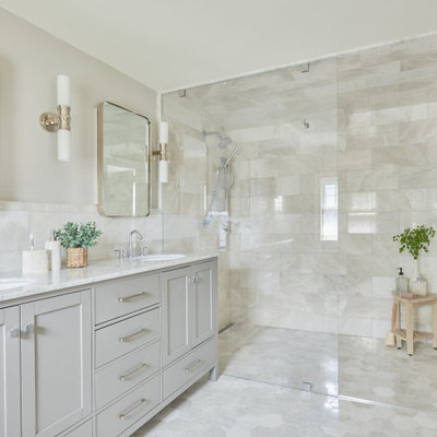 Example of a transitional master gray tile and marble tile marble floor, gray floor and double-sink walk-in shower design in Other with shaker cabinets, gray cabinets, gray walls, marble countertops, a hinged shower door, gray countertops, an undermount sink and a freestanding vanity