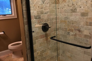 Inspiration for a mid-sized timeless 3/4 multicolored tile and stone tile travertine floor bathroom remodel in New York with furniture-like cabinets, brown cabinets, a two-piece toilet, brown walls and granite countertops