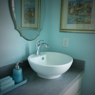Exemple d'une salle d'eau romantique de taille moyenne avec une vasque, un placard à porte shaker, des portes de placard blanches, un plan de toilette en stratifié et un mur bleu.