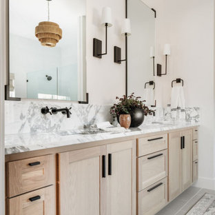 Bild på ett stort vintage vit vitt en-suite badrum, med skåp i shakerstil, skåp i ljust trä, ett fristående badkar, en dubbeldusch, en toalettstol med hel cisternkåpa, vit kakel, porslinskakel, vita väggar, klinkergolv i porslin, ett väggmonterat handfat, marmorbänkskiva, grått golv och dusch med gångjärnsdörr