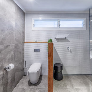 Photo of a contemporary 3/4 wet room bathroom in Brisbane with flat-panel cabinets, black cabinets, a one-piece toilet, gray tile, grey walls, grey floor, an open shower and white benchtops.
