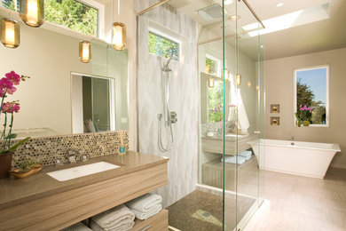 Bathroom - large contemporary master beige tile and mosaic tile vinyl floor bathroom idea in Seattle with an undermount sink, light wood cabinets, beige walls, flat-panel cabinets and solid surface countertops