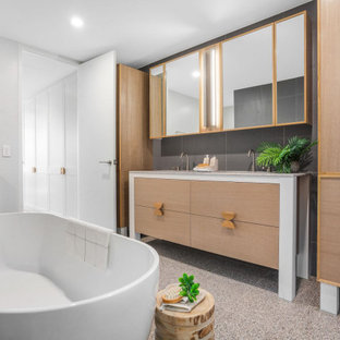 This is an example of a contemporary master bathroom in Central Coast with flat-panel cabinets, medium wood cabinets, a freestanding tub, gray tile, multi-coloured benchtops, a double vanity and a built-in vanity.