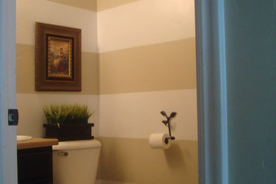 Example of a classic beige tile powder room design in Other with a two-piece toilet