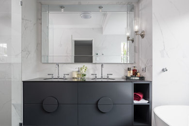 Freestanding bathtub - mid-sized contemporary master porcelain tile black floor, double-sink and tray ceiling freestanding bathtub idea in Perth with black cabinets, a one-piece toilet, an undermount sink, tile countertops, black countertops, a floating vanity and a niche