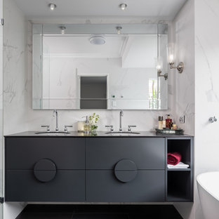 Design ideas for a mid-sized contemporary master bathroom in Perth with black cabinets, a freestanding tub, a one-piece toilet, porcelain tile, an undermount sink, tile benchtops, black floor, black benchtops, a double vanity, a floating vanity, a niche and recessed.