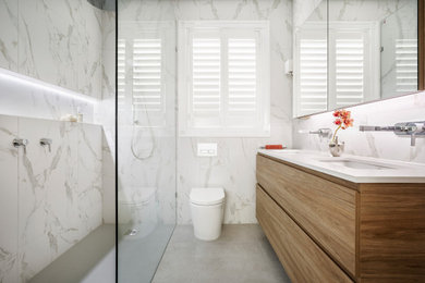 Réalisation d'une douche en alcôve design en bois brun avec un placard à porte plane, un carrelage blanc, un lavabo encastré, un sol gris, un plan de toilette blanc, une niche, meuble double vasque et meuble-lavabo suspendu.