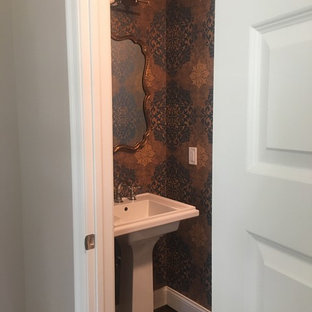 Example of a small eclectic dark wood floor, brown floor, wallpaper ceiling and wallpaper bathroom design in New York with a pedestal sink and a two-piece toilet