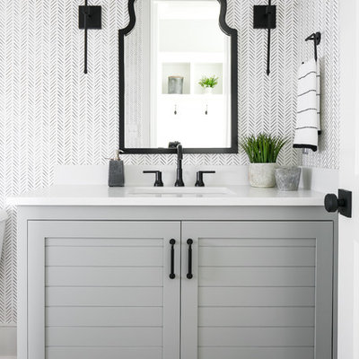 Inspiration for a transitional dark wood floor and brown floor bathroom remodel in Louisville with furniture-like cabinets, gray cabinets, multicolored walls, an undermount sink and white countertops