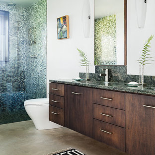 Diseño de cuarto de baño con ducha, actual, con lavabo integrado, armarios con paneles lisos, puertas de armario de madera en tonos medios, ducha empotrada, sanitario de una pieza, baldosas y/o azulejos multicolor, baldosas y/o azulejos en mosaico, paredes blancas y suelo de cemento