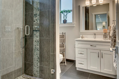 Corner shower - mid-sized traditional 3/4 porcelain tile ceramic tile and beige floor corner shower idea in Seattle with shaker cabinets, white walls, an undermount sink, quartz countertops, a hinged shower door and white countertops