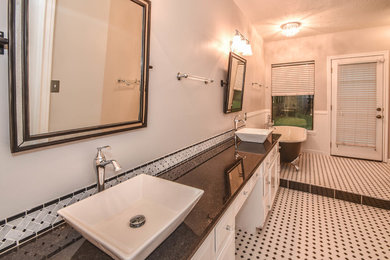 Inspiration for a transitional master black and white tile and mosaic tile mosaic tile floor bathroom remodel in Houston with raised-panel cabinets, white cabinets, a one-piece toilet, gray walls, a vessel sink and granite countertops