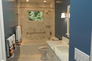 Bathroom - mid-sized eclectic black and white tile and stone tile marble floor bathroom idea in San Francisco with recessed-panel cabinets, a two-piece toilet, blue walls, an undermount sink and marble countertops