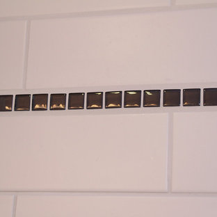 Kleines Klassisches Badezimmer En Suite mit flächenbündigen Schrankfronten, dunklen Holzschränken, Eckbadewanne, Duschbadewanne, Wandtoilette mit Spülkasten, weißen Fliesen, Metrofliesen, lila Wandfarbe, Vinylboden, integriertem Waschbecken und Mineralwerkstoff-Waschtisch in Milwaukee
