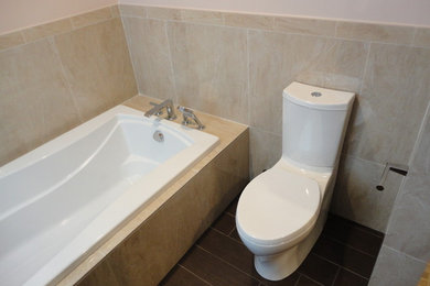 Imagen de cuarto de baño principal tradicional de tamaño medio con bañera encastrada, sanitario de dos piezas y suelo de baldosas de porcelana